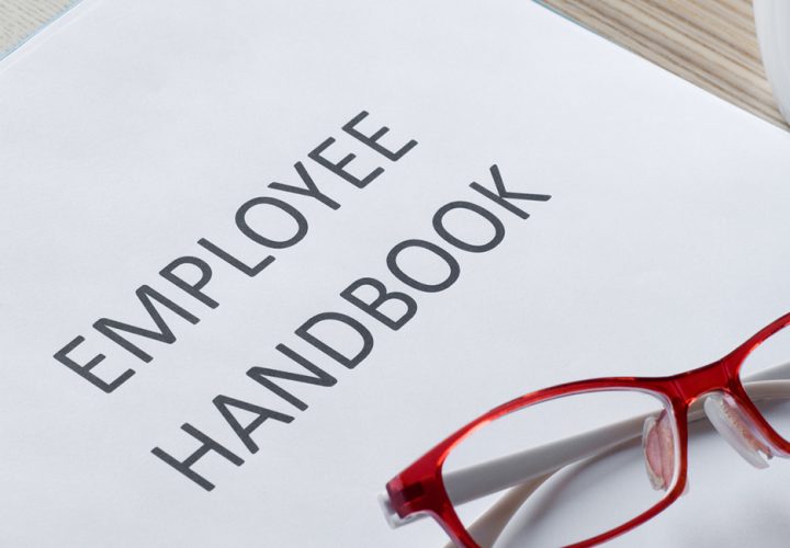red reading glasses on employee handbook