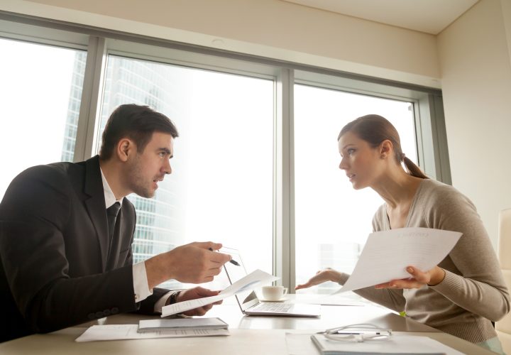 Colleagues arguing at workplace, disagree about document, error in contract